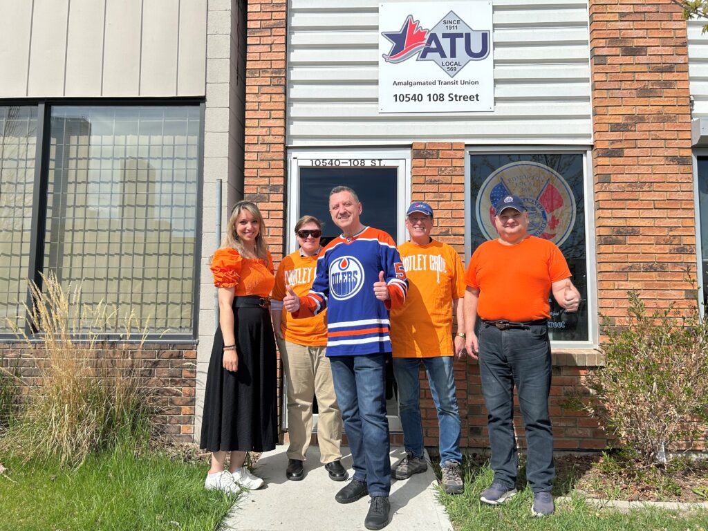 5 ATU office staff wearing orange and blue for the Oilers hockey team